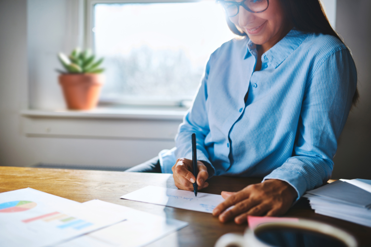 Woman smiling as she works on a project at home for her own business